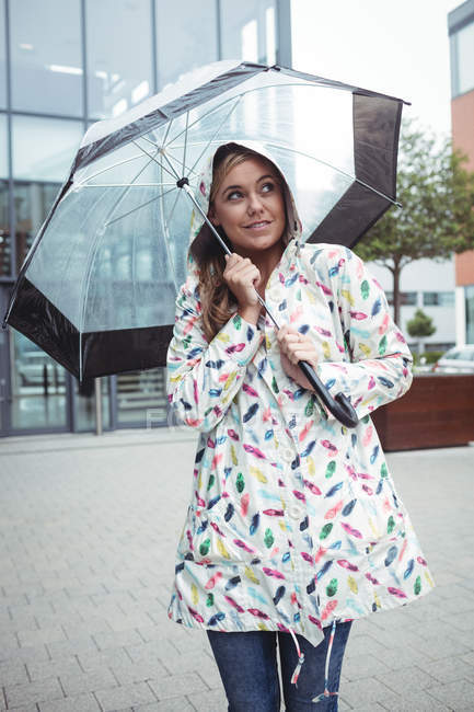 Belle femme tenant parapluie pendant la saison des pluies — Photo de stock