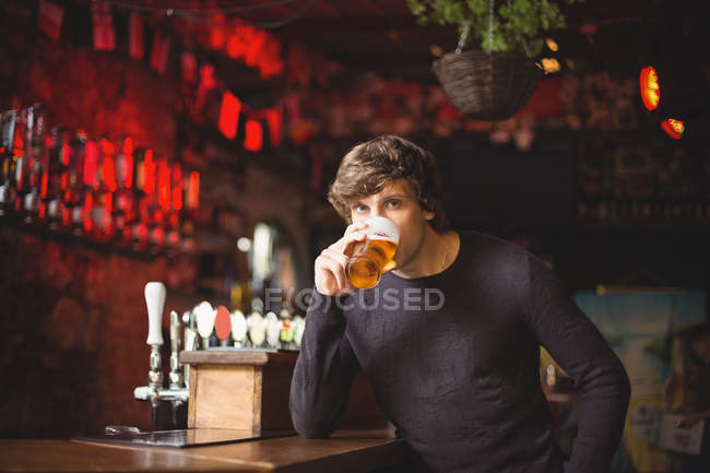 Retrato de homem tomando um copo de cerveja no bar — Fotografia de Stock