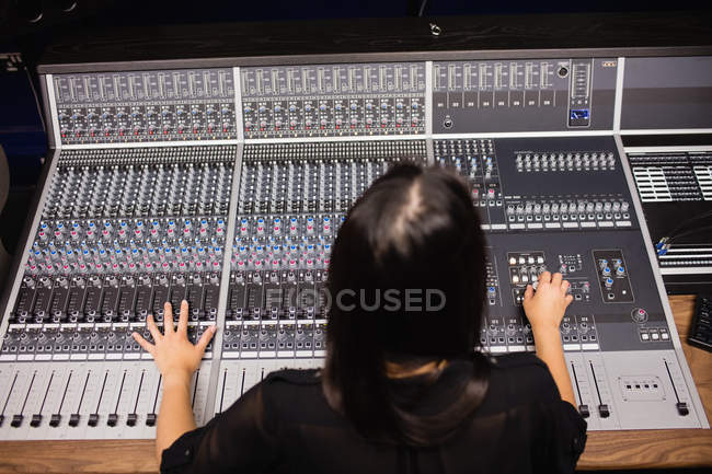 Estudiante usando mezclador de sonido en un estudio - foto de stock