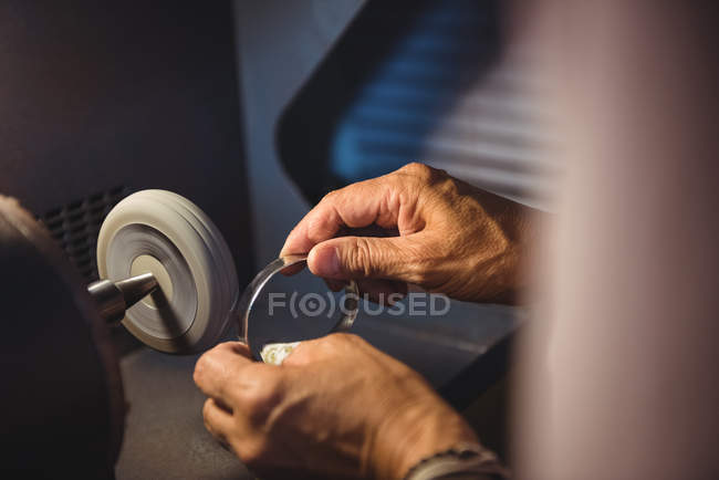 Mains d'artisan travaillant sur une machine en atelier — Photo de stock