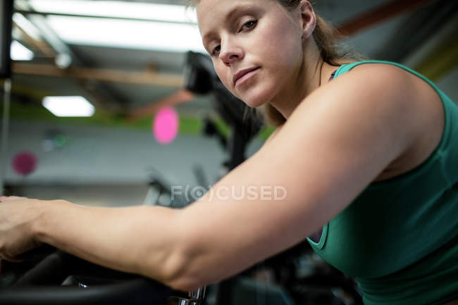 Porträt einer schwangeren Frau, die im Fitnessstudio auf dem Heimtrainer trainiert — Stockfoto