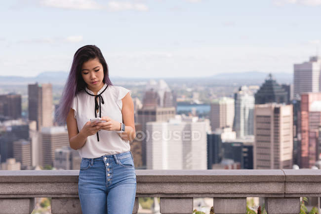 Красивая женщина с помощью мобильного телефона в солнечный день — стоковое фото