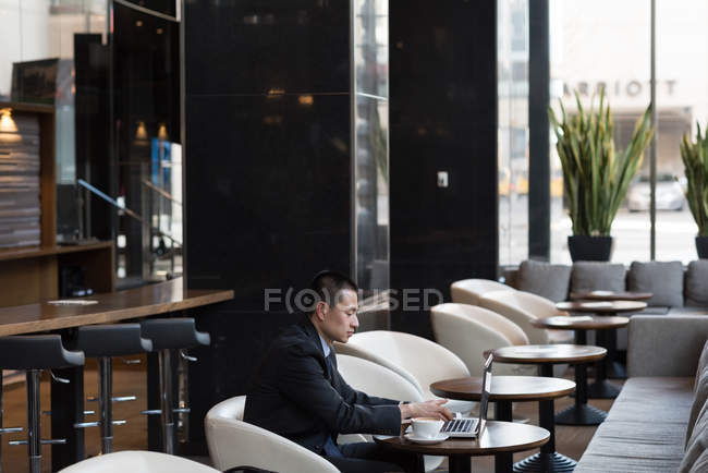 Бизнесмен с помощью ноутбука на диване в отеле — стоковое фото