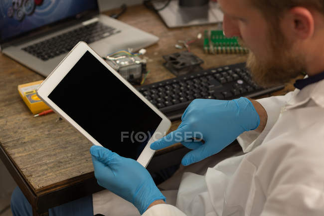 Robotics engineer using digital tablet at desk in warehouse — Stock Photo