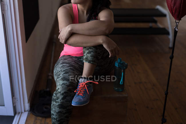 Low section of female boxer relaxing in fitness studio — Stock Photo