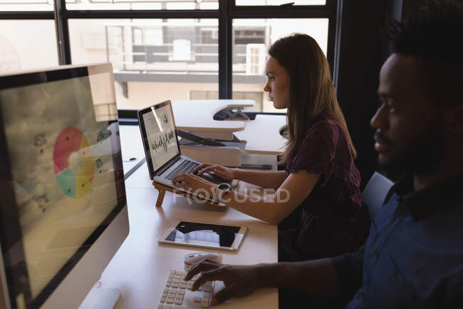 Business colleagues working at desk in office — Stock Photo