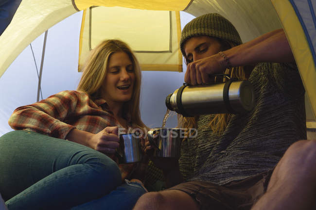 Jeune couple prenant un café dans la tente — Photo de stock