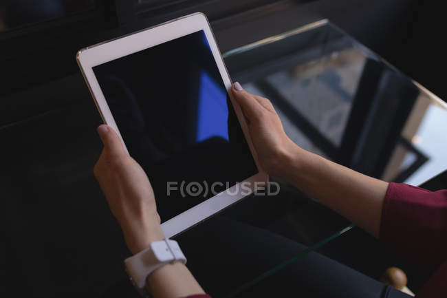 Mid section of female executive holding digital tablet in office — Stock Photo