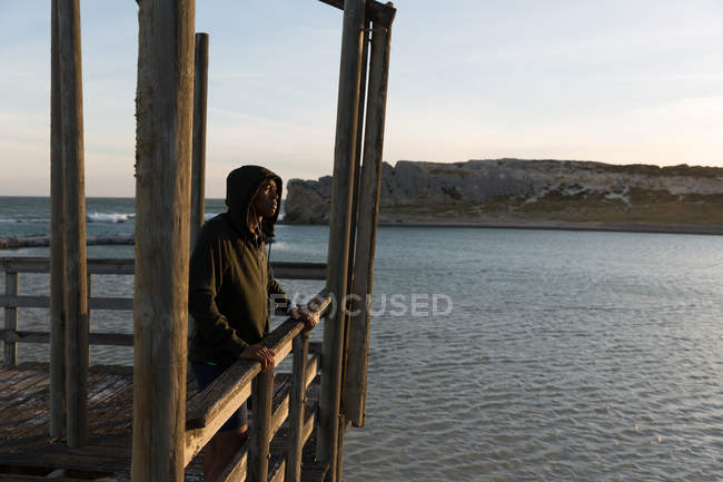 Thoughtful male athlete standing on pier — Stock Photo