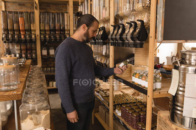 Mann blickt auf Getreideflasche in Getreide- und Getreideabteilung im Supermarkt — Stockfoto