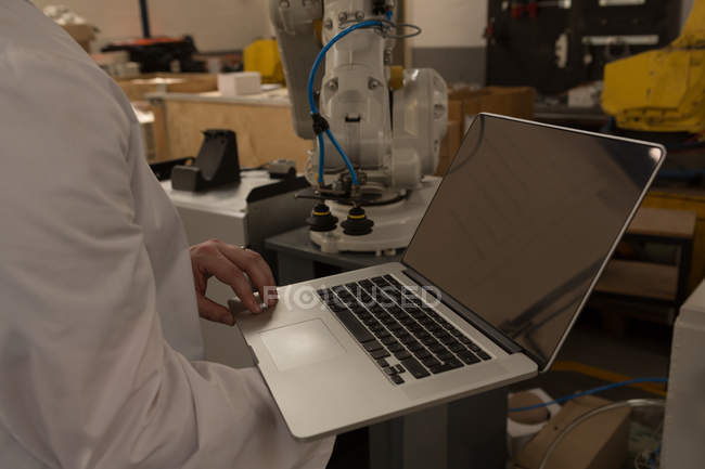 Средняя секция инженера-робота с помощью ноутбука на складе — стоковое фото