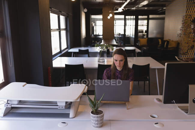 Femme d'affaires utilisant un ordinateur portable au bureau — Photo de stock