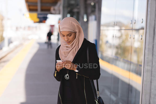Hijab mulher usando telefone celular na plataforma na estação — Fotografia de Stock