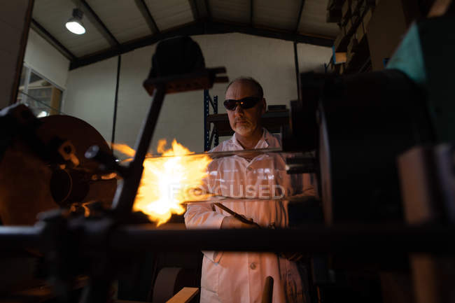 Trabalhador masculino usando tocha de soldagem na fábrica de vidro — Fotografia de Stock