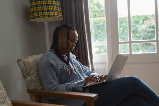 Women using laptop in a living room at home — Stock Photo