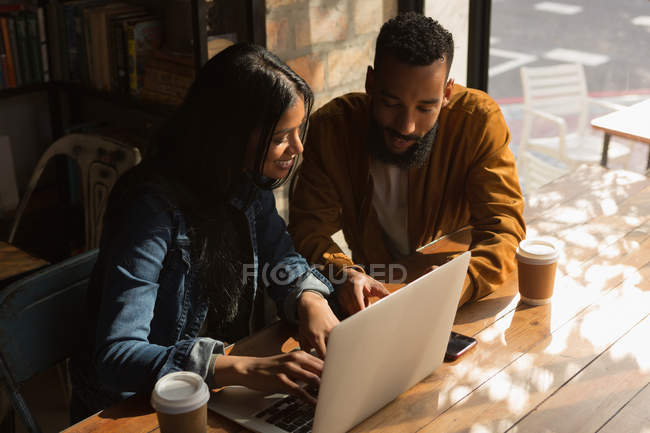 Romantic couple using laptop in cafe — Stock Photo