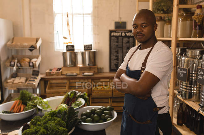 Porträt eines männlichen Personals, das mit verschränkten Armen im Supermarkt steht — Stockfoto