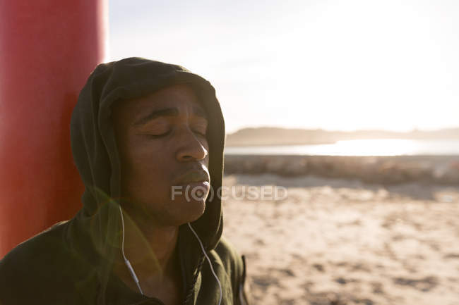 Close-up of male athlete relaxing at beach — Stock Photo