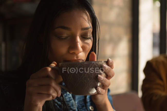 Крупним планом жінка має каву в кафе — стокове фото