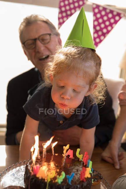 Niedliches Mädchen bläst Geburtstagskerze zu Hause — Stockfoto