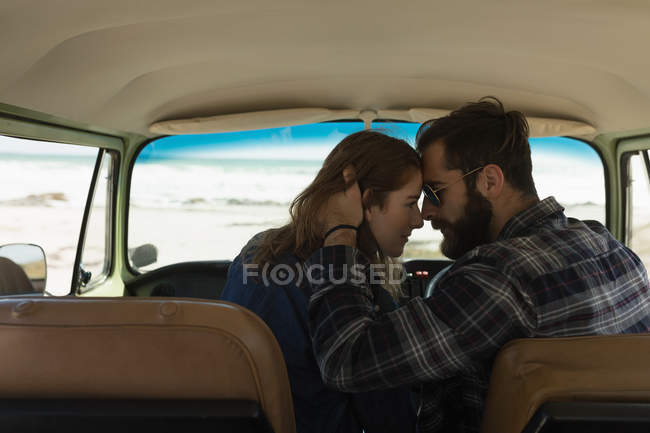 Romantic couple embracing in vehicle on roadtrip — Stock Photo