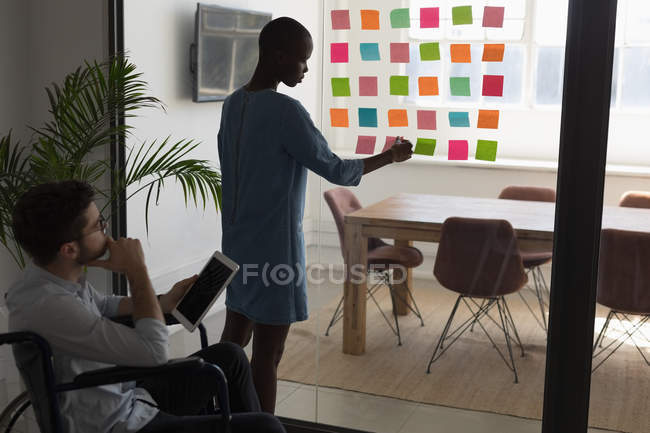 Executives working on sticky notes in office — Stock Photo