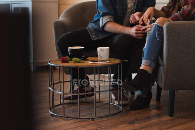 Low section of couple romancing in cafe — Stock Photo