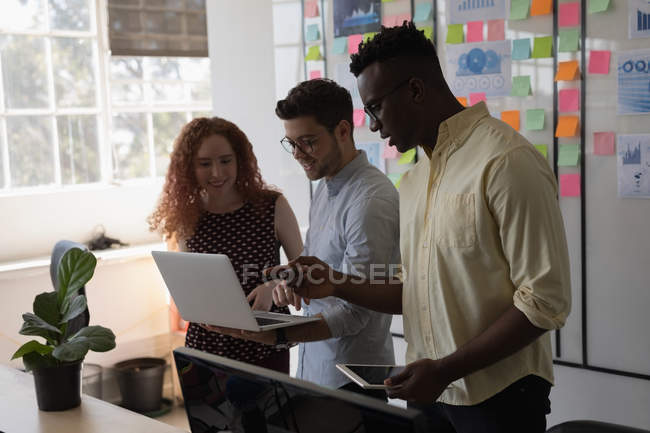 Executivos discutindo sobre laptop no escritório — Fotografia de Stock