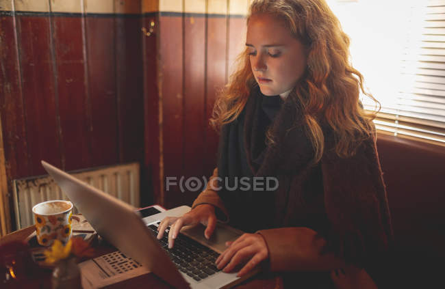 Mulher ruiva usando laptop no café — Fotografia de Stock