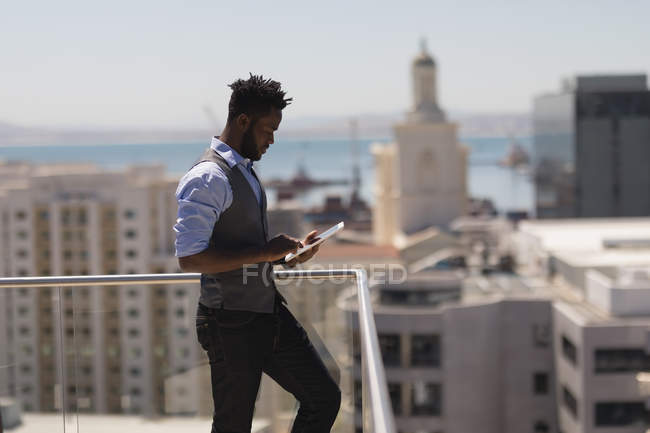 Бизнесмен с помощью цифрового планшета на террасе в офисе — стоковое фото