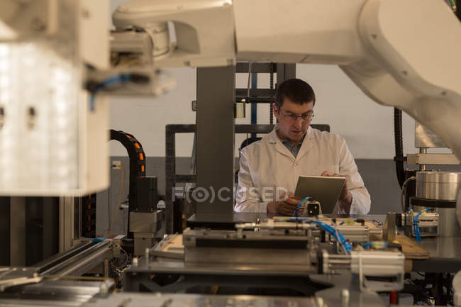 Ingénieur robotique utilisant une tablette numérique dans un entrepôt — Photo de stock