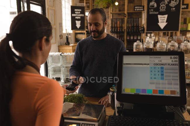 Customer making payment at counter in supermarket — Stock Photo