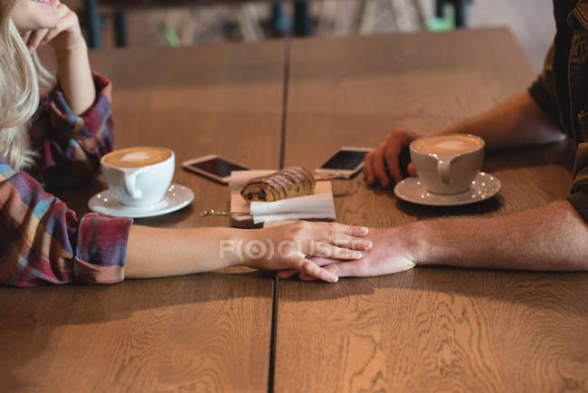 Romantic couple holding hand in cafe — Stock Photo