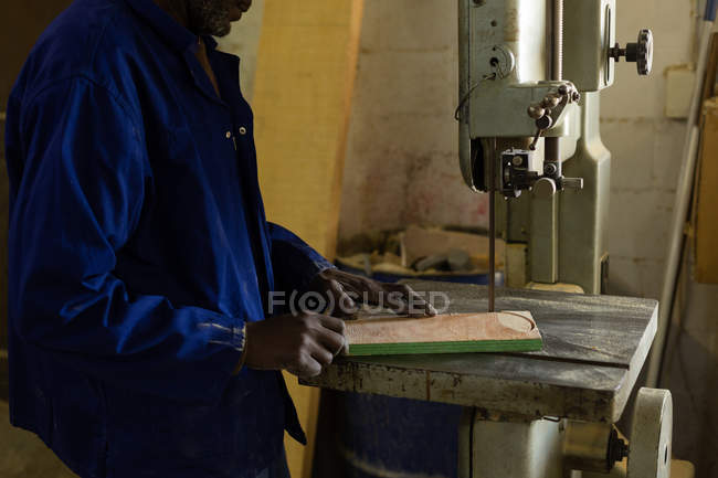 Sección media del trabajador que utiliza la máquina de sierra en el taller de fundición - foto de stock