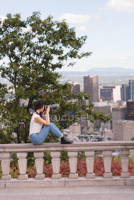 Vista lateral da mulher clicando foto no telefone móvel — Fotografia de Stock