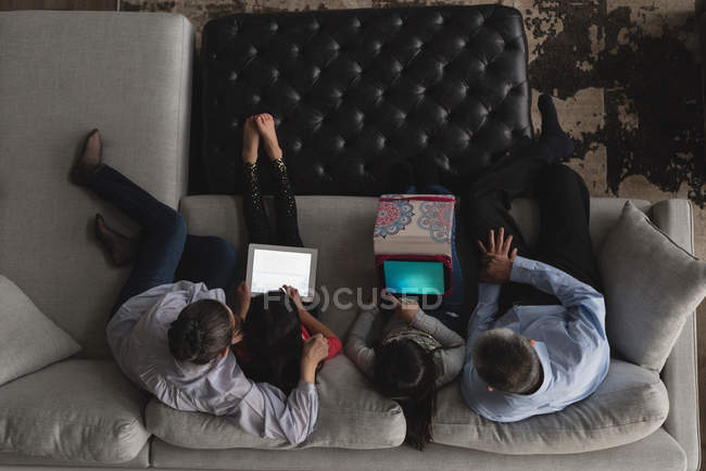 Overhead of grandparents with their using digital tablet on sofa in living room at home — Stock Photo