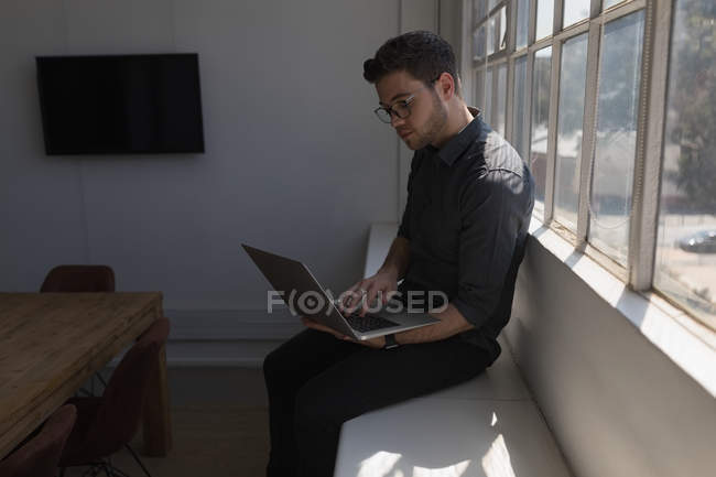 Executivo masculino usando laptop no escritório — Fotografia de Stock