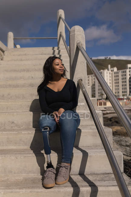 Nachdenkliche behinderte Frau sitzt auf Treppe — Stockfoto