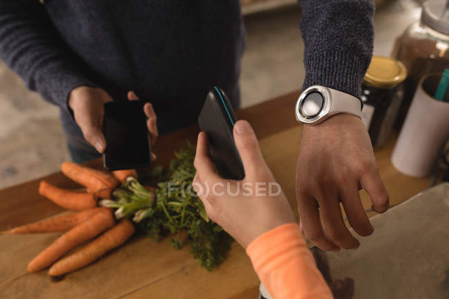 Cliente haciendo el pago a través de smartwatch en el mostrador en el supermercado - foto de stock