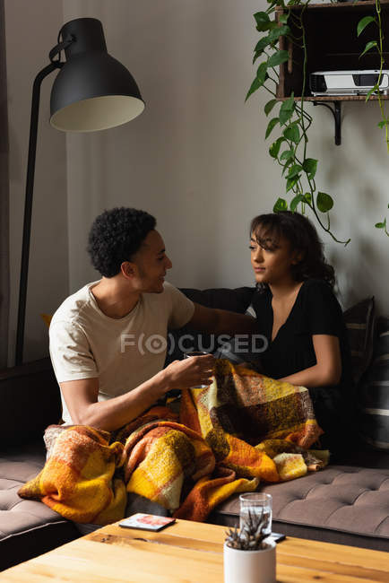 Пара взаємодіє один з одним на дивані у вітальні вдома — стокове фото