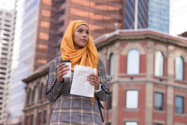 Thoughtful hijab woman having coffee in city — Stock Photo