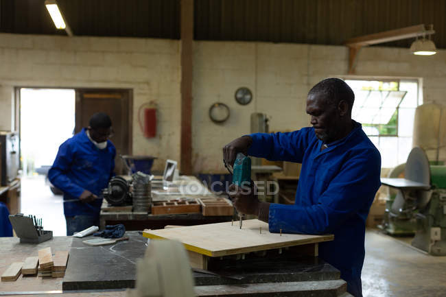 Travailleur masculin utilisant une perceuse dans un atelier de fonderie — Photo de stock