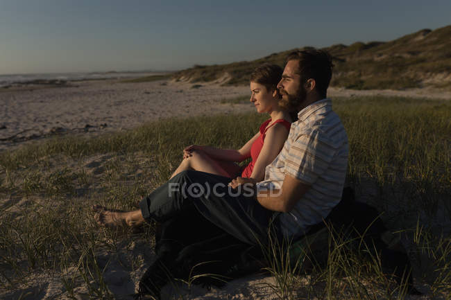 Seitenansicht eines am Strand sitzenden Paares — Stockfoto