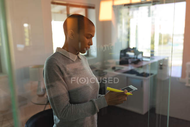Жіночий бізнес виконавчий за допомогою мобільного телефону в офісі — стокове фото
