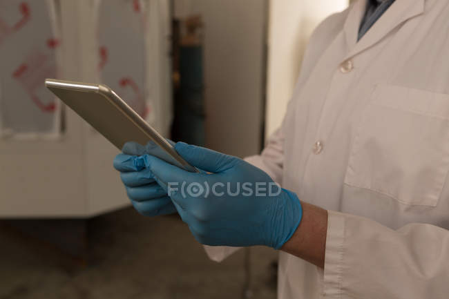 Mid section of robotics engineer using digital tablet in warehouse — Stock Photo