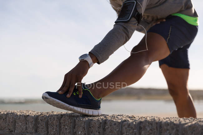 Close-up of male athlete stretching on surrounding wall — Stock Photo