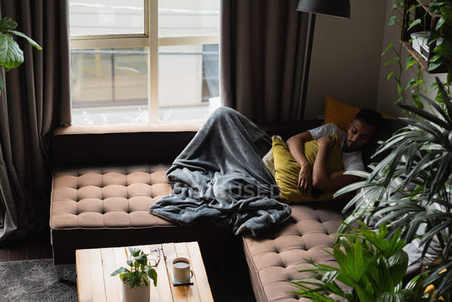 Homem dormindo no sofá na sala de estar em casa — Fotografia de Stock