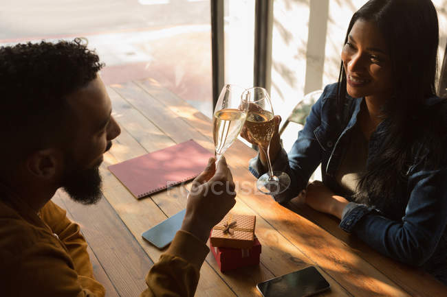 Счастливая пара пьет бокал вина в кафе — стоковое фото