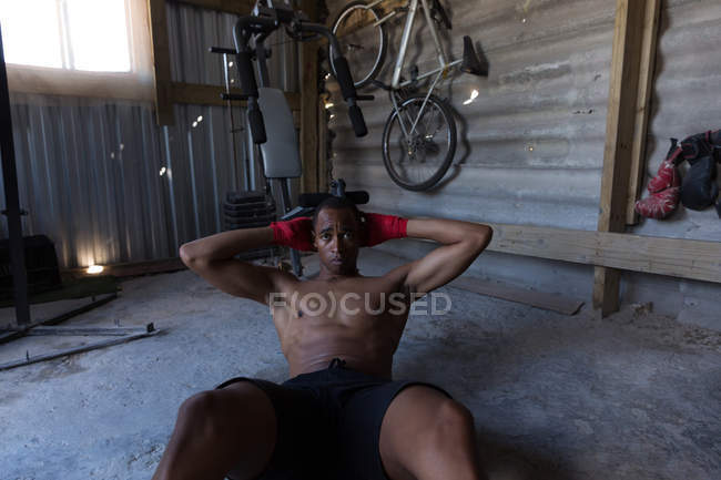 Boxeur masculin déterminé faisant de l'exercice dans un club de boxe — Photo de stock