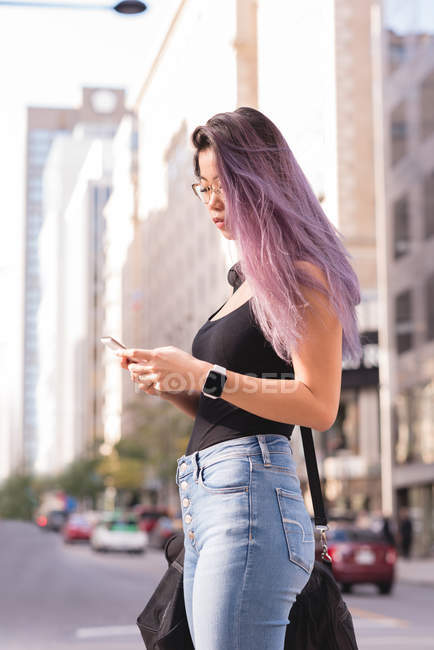 Frau benutzt Handy an einem sonnigen Tag in der Stadt — Stockfoto